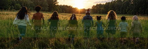 Group of children walking together through a field at sunset
